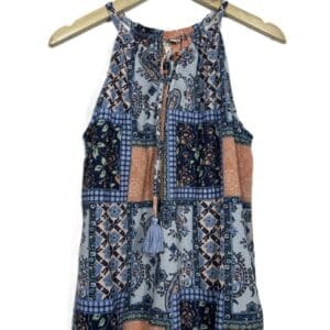 The (Cato) Blue & Peach Top is a sleeveless women's top with a blue, orange, and white patchwork pattern, featuring a high neckline with tie and tassel details, displayed on a wooden hanger.