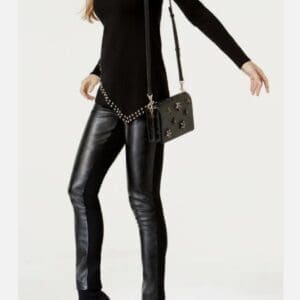 Wearing a black long-sleeve top, Blk Faux Lthr Frnt pants, black ankle boots, and carrying a studded black crossbody bag.