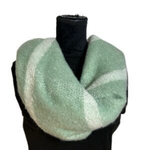 A black mannequin displays the Teal, White, & Sparkle Soft Scarf looped around its neck against a white background.
