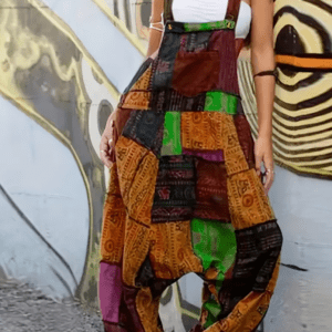 A person wearing Colorful Patchwork Overalls and a white tube top poses in front of a mural.