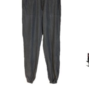 Dark Grey Denim Joggers with elastic waistband and cuffs, two front pockets, shown hanging on a black hanger against a white background.