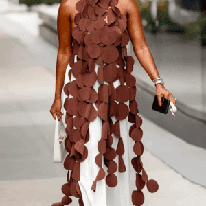 Person wearing the Brown Round Long String dress with large circular cutouts, layered over white pants, walking outdoors holding a white bag and black phone.