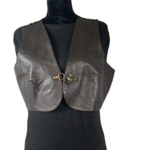 A black leather vest with a front buckle closure displayed on a black mannequin torso against a white background.