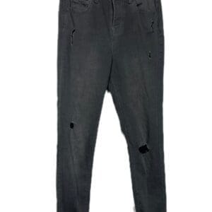 A pair of black distressed jeans with ripped details and frayed hems, hanging on a hanger against a white background.
