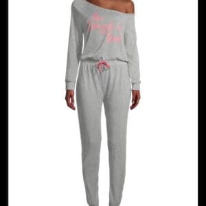 A person wearing a light gray, off-the-shoulder, long-sleeve jumpsuit with pink text that reads "The Struggle is Real" and a pink drawstring at the waist.