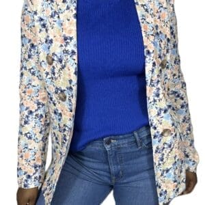 Person wearing a blue ribbed top, blue jeans, and a floral-patterned blazer with large buttons, shown from shoulders to thighs against a white background.