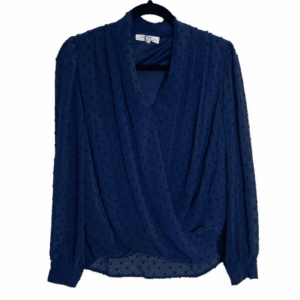 The Blue Navy Long Sleeve Bump Blouse features a surplice front and subtle textured dot pattern, displayed on a black hanger against a white background.