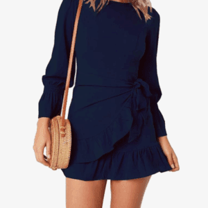 Woman wearing a Navy Short Ruffle Bottom and Long Ruffle Sleeve Dress, carrying a round straw crossbody bag, stands against a white background.