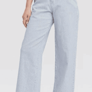 Woman wearing light blue wide-leg pants and a beige top.