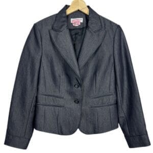 A Lena Gabrielle dark blue denim women's blazer with two buttons, notched lapel collar, and two front welt pockets, hanging on a wooden hanger.