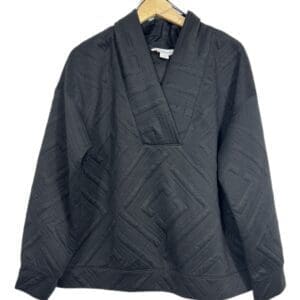 The Blk Hgh Neck Quilt, a black quilted long-sleeve pullover with a wide structured collar, hangs on a wooden hanger against a white background.