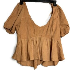 Light brown, short-sleeved, textured blouse with a deep V-neckline, gathered waist, and asymmetrical hem, displayed on a black hanger against a white background.