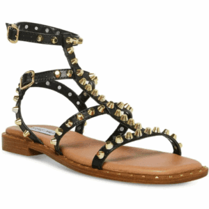 Black strappy sandal with gold studs, ankle strap, polka dot lining, and a flat wooden sole.