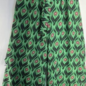 Double Layer Wide Leg Tie Waist Pants in green feature a high waist, bold geometric pattern with pink flowers and black leaf shapes, loose fit, and knee-length cut.