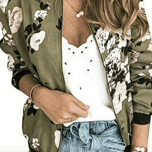A woman wears a Flowered Black Trimmed Jacket over a white lace top and high-waisted denim shorts with a tied belt.