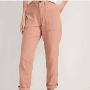 A person wearing High Rise Krinkly Pants in light pink, featuring a high waist, front pockets, and rolled cuffs, with their hands in the pockets.