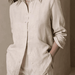 A person wearing the Long Sleeve Linen Shirt in light beige with rolled-up sleeves and matching pants stands with hands in pockets.