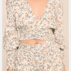 A person wearing the Flower Low Cut Long Sleeve Crop Top with matching floral print shorts, featuring a V-neckline and ruched details.