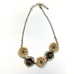 The Flowered Tie Back Crop Top features a floral design in beige and brown tones, showcased against a white background.