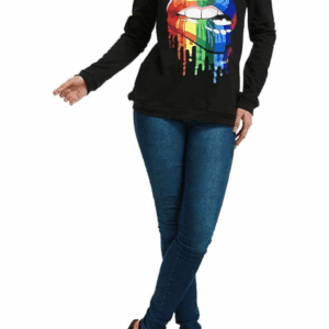 A person wearing the Off the Shoulder Be Bold Top, featuring a black long-sleeve design with a rainbow lips graphic, paired with blue jeans and black high heels.