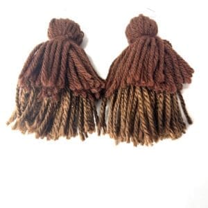 A pair of handmade earrings made from thick brown and tan yarn strands, resembling tassels, displayed on a white background.