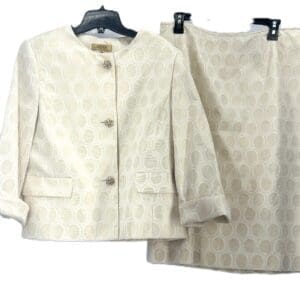 Cream-colored skirt suit set with a textured oval pattern, featuring a buttoned jacket with two front pockets and a matching knee-length skirt, both displayed on hangers.