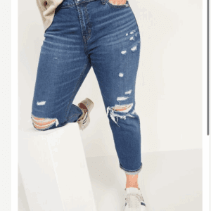 Person wearing distressed blue jeans, white sneakers, and the Off the Shoulder Be Bold Top with one leg resting on a white rectangular block.