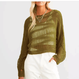 A person wearing the Wavy Green Yarn Cropped Sweater over a sheer top, paired with high-waisted white pants and layered silver necklaces.