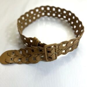 The Wide Camel Belt, crafted from tan woven leather with a square buckle, is displayed on a white surface.