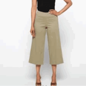 Person wearing beige 6 Button Pocket Dress Pants and a black sleeveless top, standing with one hand on hip against a plain background.
