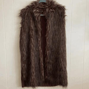 The Brown Faux Fur Long Vest, a sleeveless design, is displayed on a black hanger against a light-colored wall.
