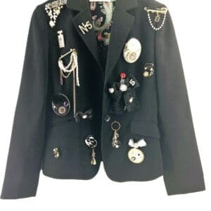 The Custom Blazers feature a black design with decorative pins, brooches, and chains attached to the front panels and lapels.