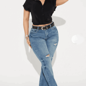 A person poses against a white background wearing a black short-sleeve button-up shirt, blue high-waisted ripped jeans, a belt, and bracelets.