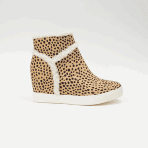 The Faux Fur Suede Hidden Wedge Sneaker features a tan ankle boot design with black spots, white faux fur trim, and a white sole, displayed on a plain white background.