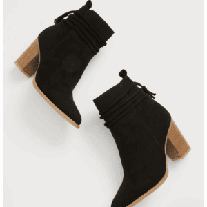 The Black Tassel Pointed Toe Heeled Boot features black suede, chunky light brown heels, and decorative wrap details around the ankle, shown against a white background.
