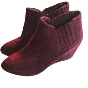 A pair of maroon suede wedge ankle boots with elastic side panels, displayed on a white background.