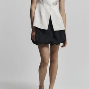A person wearing a sleeveless white blazer and the Dakota Blue Bubble Skirt stands against a plain light background.