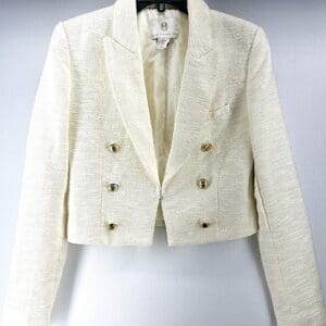 The Change of Plans Cropped Bomber is a cream-colored, textured blazer with long sleeves, notched lapels, and six gold buttons, shown on a hanger against a plain background.