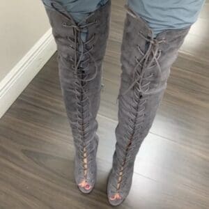 Person wearing Tie Up Over the Knee Denim Boot SIZE 8, standing on a wooden floor near a white baseboard.