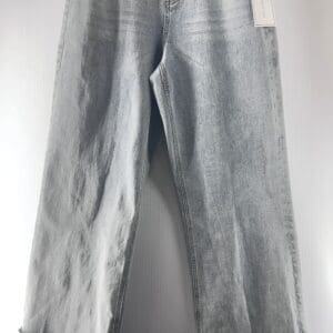 Light blue wide-leg jeans with rolled cuffs, front pockets, belt loops, and a tag attached to the waistband, displayed against a plain background.