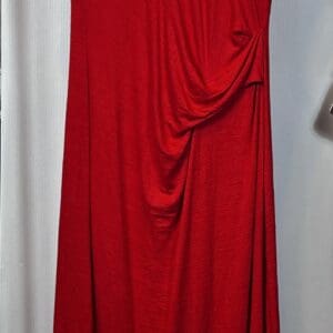 Product is a sleeveless red maxi dress featuring draped waist detail, shown on a hanger against a light background.