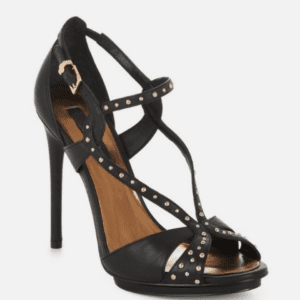 Black high-heeled sandal with crisscross straps and small metallic studs, featuring an ankle buckle and open toe design.