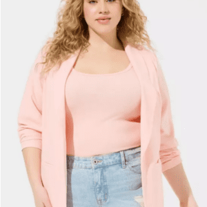 A woman with long curly blonde hair wears the Pink Lightweight Blazer over a matching top and light blue high-waisted jeans, standing against a plain light background.
