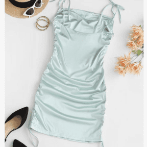 A Thin One Shoulder Shirt Dress in light blue (size S) is laid out beside a straw hat, white sunglasses, gold bangles, black heels, and peach-colored flowers.