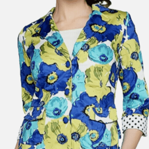 A woman wears the Spring Flower Quarter Length Sleeve Blazer SIZE 14, featuring a blue, yellow, and green floral pattern with rolled-up sleeves showing a black and white polka dot lining.