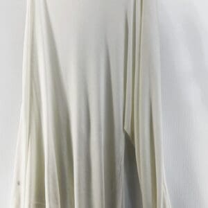 A Thin One Shoulder Shirt Dress in off-white, size S, featuring an asymmetrical design and single draped sleeve, is shown hanging on black clips against a white background.