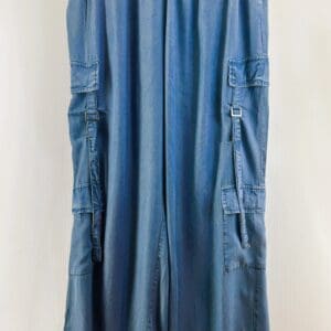 Light Denim 6 Pocket Wide Leg Cargo Jeans in size L, featuring an elastic waistband, side and flap pockets on each leg, shown hanging on a hanger against a plain background.