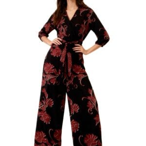 Woman standing with hands on hips, wearing the Red Flower Long Sleeve Wide Leg Tie Waist Jumpsuit (SIZE XL) against a white background.