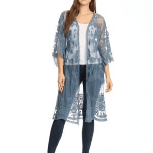 A woman wearing a blue sheer lace kimono over a white top and dark jeans, standing against a plain white background.
