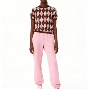 A person stands facing forward against a plain white background, wearing the Diamond Knit Sweater SIZE L in brown and pink, paired with light pink sweatpants and white sneakers.
